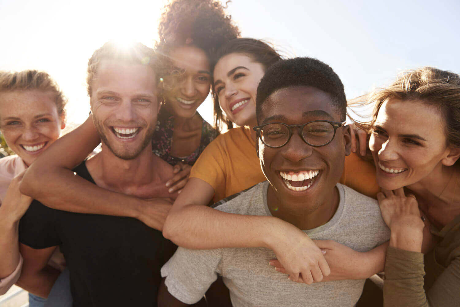 friends laughing and holding onto each other outside